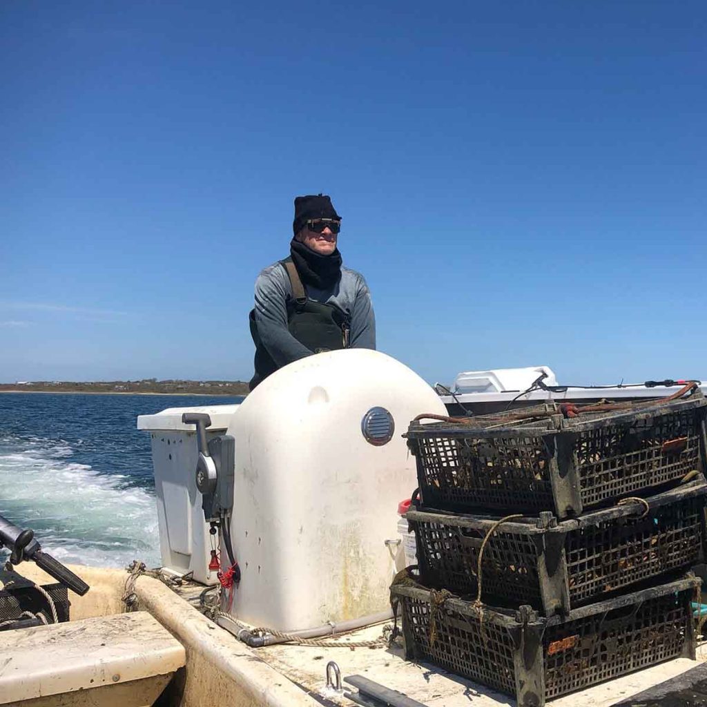 Chris driving boat with oysters on board