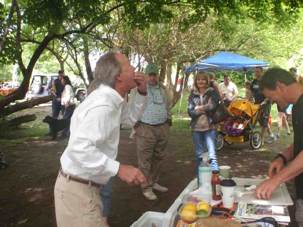 Governor Chafee tasting oysters at outdoor event