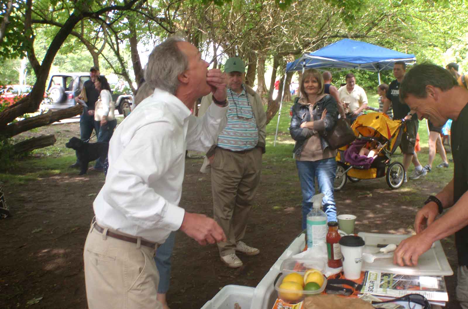 Governor Chafee tasting oysters at outdoor event